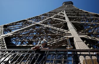 TOPSHOT - A visitor wearing a protective facemask admires the view from the Eiffel Tower during its partial reopening on June 25, 2020, in Paris, as France eases lockdown measures taken to curb the spread of the COVID-19 caused by the novel coronavirus. - Tourists and Parisians will again be able to admire the view of the French capital from the Eiffel Tower after a three-month closure due to the coronavirus -- but only if they take the stairs. (Photo by Thomas SAMSON / AFP) (Photo by THOMAS SAMSON/AFP via Getty Images)