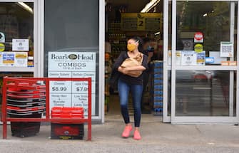 1252597113 NEW YORK, NEW YORK - JUNE 25: A person wears a protective face mask outside a supermarket in Brooklyn as New York City moves into Phase 2 of re-opening following restrictions imposed to curb the coronavirus pandemic on June 25, 2020. Phase 2 permits the reopening of offices, in-store retail, outdoor dining, barbers and beauty parlors and numerous other businesses. Phase 2 is the second of four-phased stages designated by the state. (Photo by Noam Galai/Getty Images)