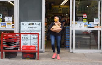 NEW YORK, NEW YORK - JUNE 25: A person wears a protective face mask outside a supermarket in Brooklyn as New York City moves into Phase 2 of re-opening following restrictions imposed to curb the coronavirus pandemic on June 25, 2020. Phase 2 permits the reopening of offices, in-store retail, outdoor dining, barbers and beauty parlors and numerous other businesses. Phase 2 is the second of four-phased stages designated by the state. (Photo by Noam Galai/Getty Images)