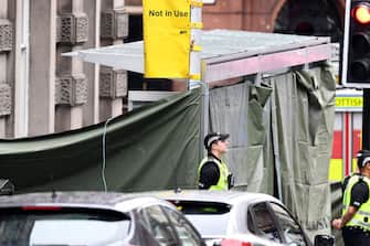 GLASGOW, SCOTLAND - JUNE 26: Police officers stand in front of a cordoned off area after reports of three people being killed in a central Glasgow hotel on June 26, 2020 in Glasgow, Scotland. A knifeman stabbed three people to death in the stairwell of the Park Inn Hotel on West George Street, Glasgow before being shot himself by armed police. The Scottish Police Federation (SPF) said an officer was stabbed during the major incident. (Photo by Jeff J Mitchell/Getty Images)