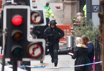 Armed specialist police officers run as they respond at the scene of a fatal stabbing incident at the Park Inn Hotel in central Glasgow on June 26, 2020. - Scottish police on Friday said armed officers shot dead a man after a suspected stabbing in Glasgow left six others injured, including one of their colleagues.  The incident happened in and around a Park Inn hotel on West George Street, in the heart of the city. Several roads were closed and the surrounding area was cordoned off. (Photo by Robert Perry / AFP) (Photo by ROBERT PERRY/AFP via Getty Images)