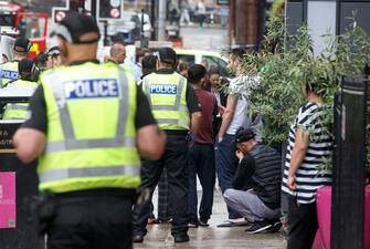 Members of the public within the police cordon react as police and emergency services respond at the scene of a fatal stabbing incident at the Park Inn Hotel in central Glasgow on June 26, 2020. - Scottish police on Friday said armed officers shot dead a man after a suspected stabbing in Glasgow left six others injured, including one of their colleagues.  The incident happened in and around a Park Inn hotel on West George Street, in the heart of the city. Several roads were closed and the surrounding area was cordoned off. (Photo by Robert Perry / AFP) (Photo by ROBERT PERRY/AFP via Getty Images)