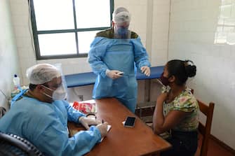 A woman is checked by members of the medical team of the Brazilian Armed Forces in Palmeiras do Javari, Amazonas state, northern Brazil, on the border with Peru, on June 18, 2020, amid the COVID-19 pandemic. - As the new coronavirus has ravaged Brazil, more than 7,000 indigenous people have contracted the virus, and more than 300 have died, according to the Brazilian Indigenous Peoples' Association (APIB), forcing many indigenous groups to take matters into their own hands. Some have locked the world out, banning outsiders and putting up a makeshift roadblock at the entrance to their territory, while others have fled into the jungle. (Photo by EVARISTO SA / AFP) (Photo by EVARISTO SA/AFP via Getty Images)