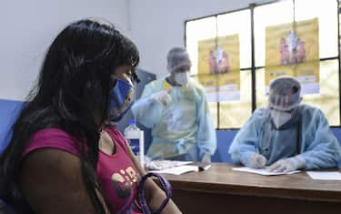 Brazilian indigenous Anita, of the Marubo ethnic group, is notified that she contracted the new coronavirus by a member of the medical team of the Brazilian Armed Forces at health post in Atalaia do Norte, Amazonas state, northern Brazil, on the border with Peru, on June 20, 2020. - As the new coronavirus has ravaged Brazil, more than 7,000 indigenous people have contracted the virus, and more than 300 have died, according to the Brazilian Indigenous Peoples' Association (APIB), forcing many indigenous groups to take matters into their own hands. Some have locked the world out, banning outsiders and putting up a makeshift roadblock at the entrance to their territory, while others have fled into the jungle. (Photo by EVARISTO SA / AFP) (Photo by EVARISTO SA/AFP via Getty Images)