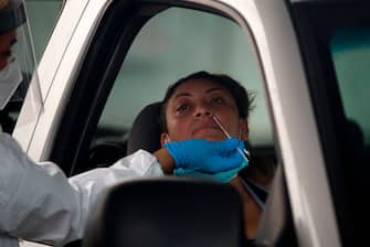 A healthcare worker administers a Covid-19 test at United Memorial Medical Center testing site in Houston, Texas, June 25, 2020. - The United States on June 25 battled a resurgence of coronavirus cases in a number of states including Texas, while the World Health Organization warned that several European countries were also facing dangerous upticks. (Photo by Mark Felix / AFP) (Photo by MARK FELIX/AFP /AFP via Getty Images)