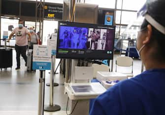 LOS ANGELES, CALIFORNIA - JUNE 24: Travelers walks past a test system of thermal imaging cameras which check body temperatures at Los Angeles International Airport (LAX) amid the COVID-19 pandemic on June 24, 2020 in Los Angeles, California. The system is being tested in the international terminal and can flag passengers who have a fever, one of the symptoms of the coronavirus. (Photo by Mario Tama/Getty Images)