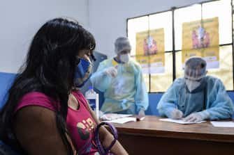 Brazilian indigenous Anita, of the Marubo ethnic group, is notified that she contracted the new coronavirus by a member of the medical team of the Brazilian Armed Forces at health post in Atalaia do Norte, Amazonas state, northern Brazil, on the border with Peru, on June 20, 2020. - As the new coronavirus has ravaged Brazil, more than 7,000 indigenous people have contracted the virus, and more than 300 have died, according to the Brazilian Indigenous Peoples' Association (APIB), forcing many indigenous groups to take matters into their own hands. Some have locked the world out, banning outsiders and putting up a makeshift roadblock at the entrance to their territory, while others have fled into the jungle. (Photo by EVARISTO SA / AFP) (Photo by EVARISTO SA/AFP via Getty Images)