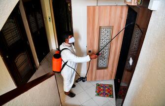 1208550900 A municipal worker sprays disinfectant in a residential area during a government-imposed nationwide lockdown as a preventive measure against the spread of the COVID-19 coronavirus in Mumbai on March 30, 2020. (Photo by Indranil MUKHERJEE / AFP) (Photo by INDRANIL MUKHERJEE/AFP via Getty Images)
