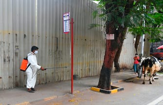 A municipal worker sprays disinfectant at a steet during a government-imposed nationwide lockdown as a preventive measure against the spread of the COVID-19 coronavirus in Mumbai on March 30, 2020. (Photo by Indranil MUKHERJEE / AFP) (Photo by INDRANIL MUKHERJEE/AFP via Getty Images)