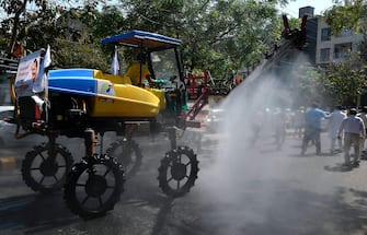 A municipal worker sprays disinfectant with a Japanese vehicle during a government-imposed nationwide lockdown as a preventive measure against the COVID-19 coronavirus in New Delhi on April 13, 2020. (Photo by Prakash SINGH / AFP) (Photo by PRAKASH SINGH/AFP via Getty Images)