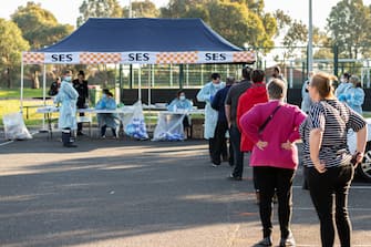 MELBOURNE, AUSTRALIA - JUNE 28: People line up at a pop-up testing facility, during a COVID-19 testing blitz in the suburb of Broadmeadows on June 28, 2020 in Melbourne, Australia. Victoria's confirmed COVID-19 infection numbers continue to rise, with 49 new coronavirus cases recorded overnight. Health authorities are continuing on a testing blitz in Melbourne suburbs that have been identified as community transmission hotspots for coronavirus. Restrictions in Victoria have been tightened in response to the spike in new cases across the state with premier Daniel Andrews extending the current state of emergency for at least four weeks to allow police the power to enforce social distancing rules. (Photo by Asanka Ratnayake/Getty Images)