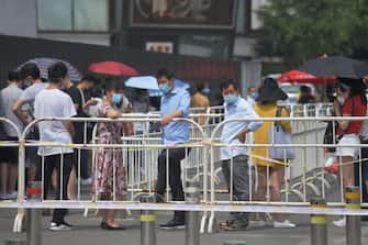People wear masks as they wait in line to undergo COVID-19 coronavirus swab tests at a testing station in Beijing on June 28, 2020. Beijing has partially lifted a weeks-long lockdown imposed in the Chinese capital to head off a feared second wave of coronavirus infections after three million samples were taken in two weeks, officials said. Dozens of residential compounds across the city were shut down, with authorities rolling out a mass testing campaign to root out any remaining cases. - Beijing has partially lifted weeks-long lockdown imposed in the Chinese capital to head off a feared second wave of coronavirus infections after three million samples were taken in two weeks, officials said. Dozens of residential compounds across the city were shut down, with authorities rolling out a mass testing campaign to root out any remaining cases. (Photo by GREG BAKER / AFP) (Photo by GREG BAKER/AFP via Getty Images)