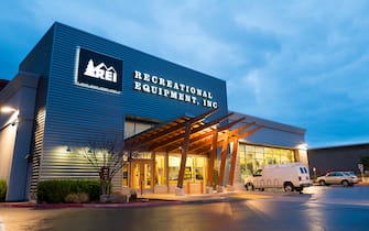 Illuminated facade at dusk with logo and sign at the Recreational Equipment Inc (REI) sports and outdoors equipment store in Dublin, California, March 12, 2018. (Photo by Smith Collection/Gado/Getty Images)