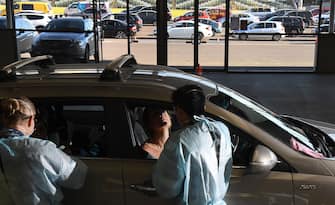 A member of the Australian Defence Force (R) takes a swab for a COVID-19 coronavirus test on a member of the public as people queue outside in their cars at a drive through testing facility in Melbourne on June 29, 2020. - The nation's second-biggest city, Melbourne, has seen a surge in COVID-19 cases over the past week, with another 75 reported in the last 24 hours. (Photo by William WEST / AFP) (Photo by WILLIAM WEST/AFP via Getty Images)