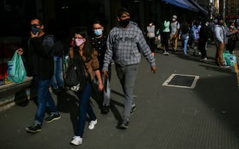 SAO PAULO, BRAZIL - JUNE 29: Shoppers wearing face masks walk in a crowded street in downtown amidst the coronavirus (COVID-19) pandemic on June 29, 2020 in Sao Paulo, Brazil. The city of Sao Paulo moves to the Yellow phase of quarantine easing, in which commercial establishments can operate following distance rules such as reduced opening hours, restricting the flow of people and maintaining hygiene standards. (Photo by Alexandre Schneider/Getty Images)