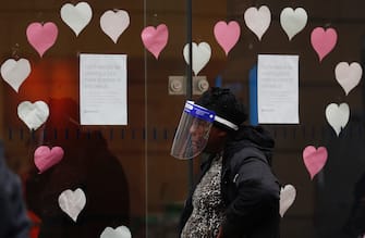 LEICESTER, ENGLAND - JULY 01: A woman wearing a face shield queues outside a Barclays bank on July 01, 2020 in Leicester, England. Ten per cent of all the recent UKs Covid-19 deaths occurred in Leicester, which became the first British city to be put into regional lockdown on Tuesday night. (Photo by Darren Staples/Getty Images)