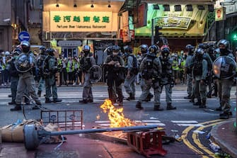 Police walk past a burning barricade set up by protesters during a rally against a new national security law in Hong Kong on July 1, 2020, on the 23rd anniversary of the city's handover from Britain to China. - Hong Kong police arrested more than 300 people on July 1 -- including nine under China's new national security law -- as thousands defied a ban on protests on the anniversary of the city's handover to China. (Photo by Anthony WALLACE / AFP) (Photo by ANTHONY WALLACE/AFP via Getty Images)