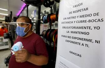 A man waits to take the temperature of customers at the entrance of his shop in Guadalajara, Jalisco State, on June 1, 2020 after Mexico began gradually reopening its economy after more than two months of shutdown because of the COVID-19 coronavirus pandemic. - With almost 10,000 COVID-19 deaths and more than 90,000 confirmed cases, Mexico is second only to Brazil in Latin America for the number of fatalities and fourth in the region in terms of infections. (Photo by Ulises RUIZ / AFP) (Photo by ULISES RUIZ/AFP via Getty Images)