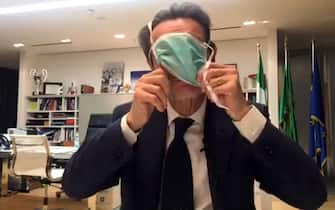 The Governor of Lombardy, Attilio Fontana, wears a protective mask in a video on Facebook as he announces the case of positivity to the Coronavirus of one of his collaborators, Milan, Italy, 26 February 2020. "From today something will change because I too will stick to the instructions given by the Higher Institute of Health, so for two weeks I will try to live in a kind of self-isolation that mainly preserves the people who work with me," Fontana said.  ANSA / A frame taken from a Facebook live of  Governor of Lombardy, Attilio Fontana   ++NO SALES; NO ARCHIVE; EDITORIAL USE ONLY++
