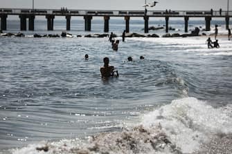 NEW YORK, NEW YORK - JULY 01: People enjoy an afternoon at the beach at Brooklyn's Coney Island on the first day that swimming is allowed at New York City beaches on July 01, 2020 in New York City. Area beaches had been closed to swimming due to concerns of crowding at beaches and the risk of spread of the coronavirus. (Photo by Spencer Platt/Getty Images)