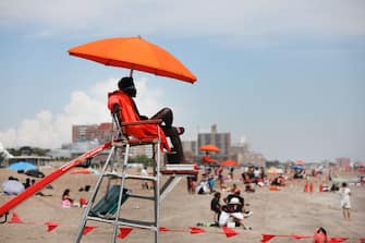 NEW YORK, NEW YORK - JULY 01: Lifeguards keep watch along the beach at Brooklyn's Coney Island on the first day that swimming is allowed at New York City beaches on July 01, 2020 in New York City. Area beaches had been closed to swimming due to concerns of crowding at beaches and the risk of spread of the coronavirus. (Photo by Spencer Platt/Getty Images)