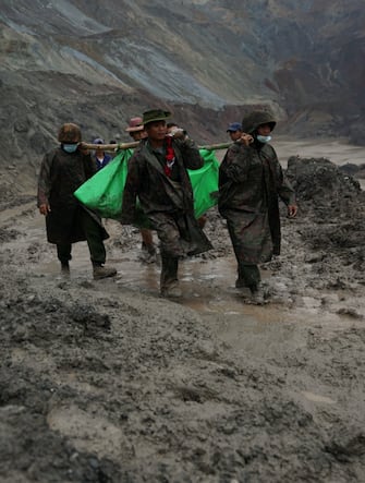 Myanmar soldiers recover bodies near the landslide area in the jade mining site in Hpakhant in Kachin state on July 2, 2020. - The battered bodies of more than 120 jade miners were pulled from a sea of mud after a landslide in northern Myanmar on July 2 after one of the worst-ever accidents to hit the treacherous industry. (Photo by ZAW MOE HTET / AFP) (Photo by ZAW MOE HTET/AFP via Getty Images)