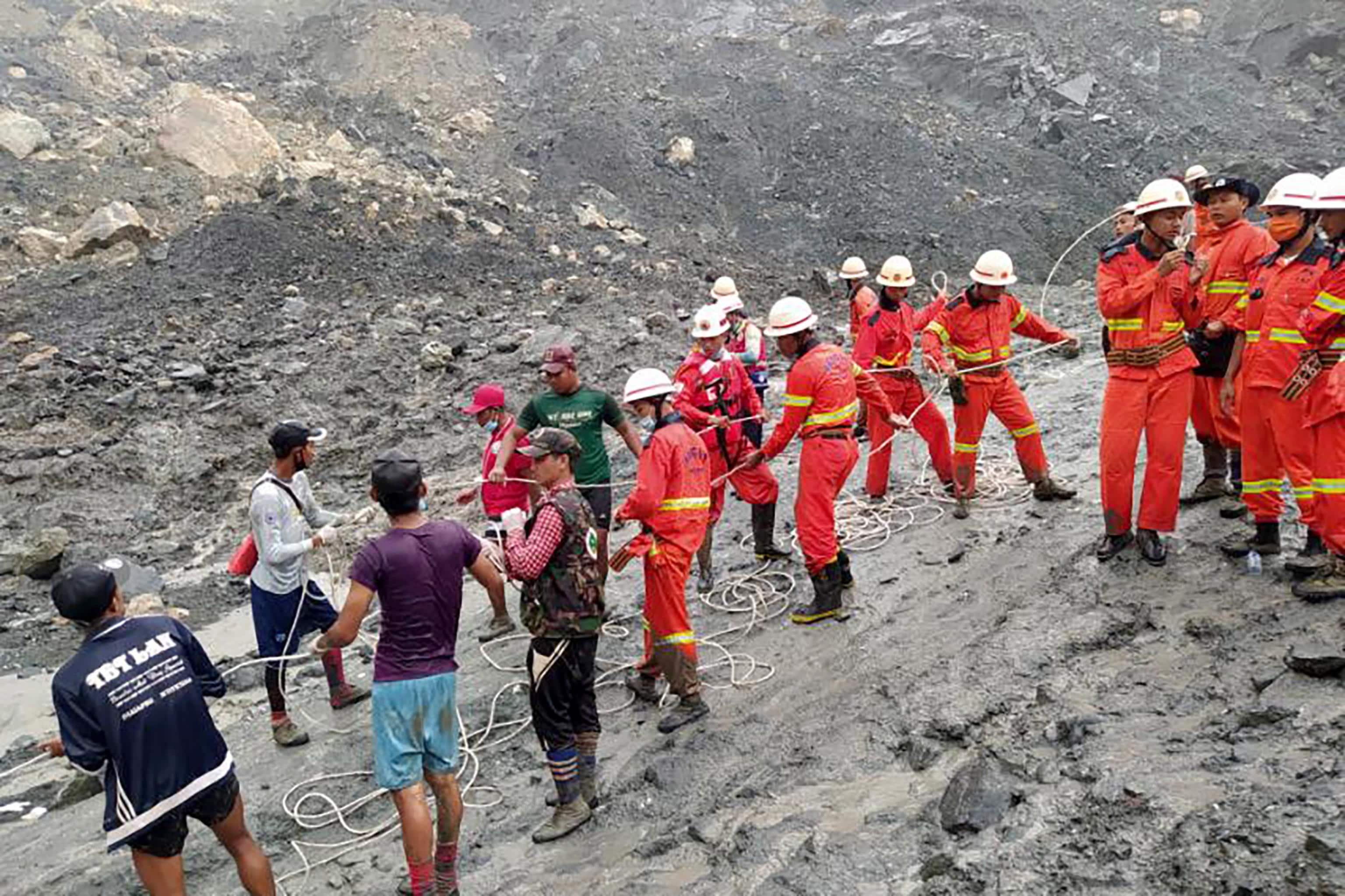 epa08522223 A handout photo made available by the Myanmar Fire Services Department shows rescue workers searching for people after a landslide accident at a jade mining site in Hpakant, Kachin State, Myanmar, 02 July 2020. According media reports, search and rescue efforts are ongoing after a landslide was triggered by heavy rain in the area.  EPA/Myanmar Fire Services Department HANDOUT  HANDOUT EDITORIAL USE ONLY/NO SALES