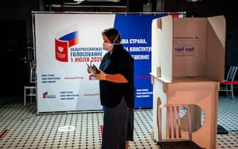 A woman wearing a face mask and gloves - a measure against the spread of the coronavirus disease - prepares to cast her ballot in a nationwide vote on constitutional reforms at a polling station inside the GULAG History Museum in Moscow on July 1, 2020. (Photo by Dimitar DILKOFF / AFP) (Photo by DIMITAR DILKOFF/AFP via Getty Images)