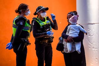 Police speak to residents outside one of nine public housing estates which have been locked down in Melbourne on July 4, 2020 with more than 3000 residents in 1,345 units required to stay home due to an outbreak of the COVID-19 coronavirus. - The Australian state of Victoria recorded its second-highest daily increase in coronavirus cases, with 108 people diagnosed with the virus. (Photo by William WEST / AFP) (Photo by WILLIAM WEST/AFP via Getty Images)