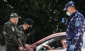 Mask-clad members of the Palestinian Authority's security forces stop vehicles at a checkpoint in the city of Nablus in the occupied West Bank on July 2, 2020, after authorities re-imposed COVID-19 coronavirus pandemic lockdown measures due to a recent spike in cases. (Photo by JAAFAR ASHTIYEH / AFP) (Photo by JAAFAR ASHTIYEH/AFP via Getty Images)
