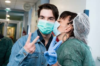 CREMONA, ITALY - APRIL 16: Mattia Guarneri gets a kiss from his mother Ombretta Contardi just after being discharged from Cremona Hospital on April 16, 2020 in Cremona, Italy. Mattia, aged 18, is the youngest person in Italy that's being discharged after being in a coma and attached to a ventilator. There have been over 150,000 reported COVID-19 cases in Italy and more than 20,000 related deaths, but the officials are confident the peak of new cases has passed. (Photo by Marco Mantovani/Getty Images)
