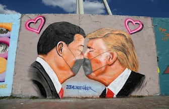 BERLIN, GERMANY - APRIL 27: Graffiti of Communist Party of China General Secretary Xi Jinping (L) and U.S. President Donald Trump kissing each other while wearing face masks is seen during the coronavirus crisis on April 27, 2020 in Berlin, Germany. Germany has launched a nationwide policy this week that people should wear protective face masks in stores and public transportation. At the same time, in an effort to dial economic activity across Germany back up, the government is easing lockdown measures imposed in March. (Photo by Adam Berry/Getty Images)