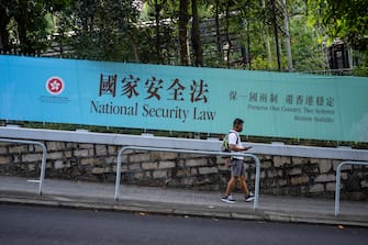 1223485889 HONG KONG, CHINA - JUNE 30: Pedestrians walks past a government-sponsored advertisement promoting a new national security law on June 30, 2020 in Hong Kong, China. (Photo by Billy H.C. Kwok/Getty Images)