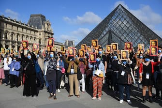 PARIS, FRANCE - JULY 06: Visitors hold reproductions of the Mona Lisa outside the Louvre museum as it reopens its doors following its 16 week closure due to lockdown measures caused by the COVID-19 coronavirus pandemic, at the Louvre on July 6, 2020 in Paris, France. (Photo by Pascal Le Segretain/Getty Images)