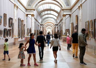 1224907802 People wearing face masks visit the Louvre Museum in Paris on July 6, 2020, on the museum' s reopening day. - The Louvre museum will reopen its doors on July 6, 2020, after months of closure due to lockdown measures linked to the COVID-19 pandemic, caused by the novel coronavirus. The coronavirus crisis has already caused "more than 40 million euros in losses" at the Louvre, announced its president and director Jean-Luc Martinez, who advocates a revival through "cultural democratization" and is preparing a "transformation plan" for the upcoming Olympic Games in 2024. (Photo by FRANCOIS GUILLOT / AFP) (Photo by FRANCOIS GUILLOT/AFP via Getty Images)