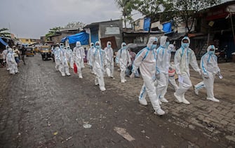 epa08530526 Indian health workers wearing personal protective equipment (PPE) leave after the medical checkup of the residents of a 'containment zones' in Ambujwadi area, a COVID-19 hotspot, in Mumbai, India, 06 July 2020. According to media reports, Indian become the third worst-affected country in the world in this coronavirus pandemic  EPA/DIVYAKANT SOLANKI