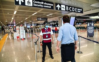 A Fiumicino airport employee wearing a "Smart-Helmet" portable thermoscanner to screen passengers and staff for COVID-19 (C), scans a fellow airport staff at boarding gates on May 5, 2020 at Rome's Fiumicino airport during the country's lockdown aimed at curbing the spread of the COVID-19 infection, caused by the novel coronavirus. (Photo by ANDREAS SOLARO / AFP) (Photo by ANDREAS SOLARO/AFP via Getty Images)