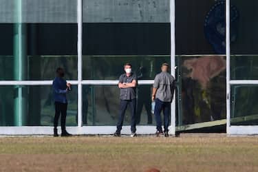 Brazilian President Jair Bolsonaro (C) is seen outside the Alvorada Palace in Brasilia on July 10, 2020. - Brazilian President Jair Bolsonaro tested positive for the coronavirus after months of downplaying the dangers of the disease. (Photo by EVARISTO SA / AFP) (Photo by EVARISTO SA/AFP via Getty Images)
