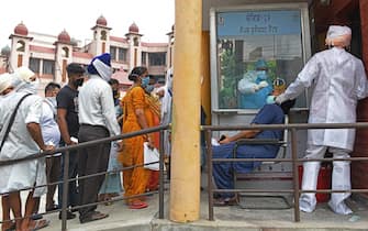 Health officials collect a nasal swab sample from a man to test for the COVID-19 coronavirus, as people wait for their turn at a civil hospital in Amritsar on July 10, 2020. - India on July 6 became the country with the third-highest coronavirus caseload in the world, as a group of scientists said there was now overwhelming evidence that the disease can be airborne -- and for far longer than originally thought. (Photo by NARINDER NANU / AFP) (Photo by NARINDER NANU/AFP via Getty Images)