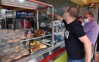Algerians buy pastries in the capital Algiers on June 7, 2020, after authorities eased some restrictions put in place in a bid to fight the spread of the novel coronavirus. (Photo by RYAD KRAMDI / AFP) (Photo by RYAD KRAMDI/AFP via Getty Images)