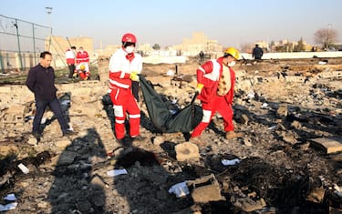 EDITORS NOTE: Graphic content / Rescue teams recover a body after a Ukrainian plane carrying 176 passengers crashed near Imam Khomeini airport in the Iranian capital Tehran early in the morning on January 8, 2020, killing everyone on board. - The Boeing 737 had left Tehran's international airport bound for Kiev, semi-official news agency ISNA said, adding that 10 ambulances were sent to the crash site. (Photo by - / AFP) (Photo by -/AFP via Getty Images)
