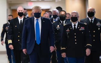 epa08541225 US President Donald J. Trump (C) wears a face mask as he arrives to visit with wounded military members and front line coronavirus healthcare workers at Walter Reed National Military Medical Center in Bethesda, Maryland, USA, 11 July 2020.  EPA/CHRIS KLEPONIS / POOL