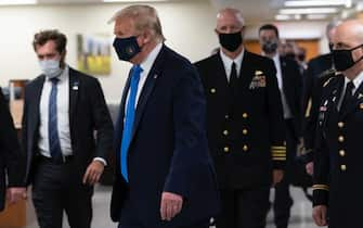 epa08541226 US President Donald J. Trump (C) wears a face mask as he arrives to visit with wounded military members and front line coronavirus healthcare workers at Walter Reed National Military Medical Center in Bethesda, Maryland, USA, 11 July 2020.  EPA/CHRIS KLEPONIS / POOL