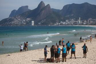 1226592854 RIO DE JANEIRO, BRAZIL - JULY 12: City hall inspectors warn and notify beach goers of new rules at Arpoador Beach amidst the coronavirus (COVID-19) pandemic on July 12, 2020 in Rio de Janeiro, Brazil. The practice of physical activities on boardwalks and individual sports at sea is allowed. However, the use of chairs and tents on the sand is still prohibited. Mayor Marcelo Crivella warned of the intensification of inspection and the imposition of a fine for those who do not comply with the rules. (Photo by Bruna Prado/Getty Images)