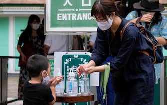 Visitors disinfect their hands as a preventive measure against the COVID-19 coronavirus as they enter Toshimaen amusement park in Tokyo on July 13, 2020. (Photo by Kazuhiro NOGI / AFP) (Photo by KAZUHIRO NOGI/AFP via Getty Images)