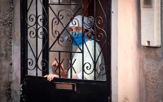 A woman stands by a building in a closed street on June 8, 2020 after Moroccan authorities declared a total lockdown following the discovery of many Covid-19 cases in a fish canning factory in the southern port city of Safi. - Morocco reported Sunday 698 additional novel coronavirus infections, the highest one-day increase since the outbreak began in early March, with numerous cases discovered in the port city. (Photo by FADEL SENNA / AFP) (Photo by FADEL SENNA/AFP via Getty Images)