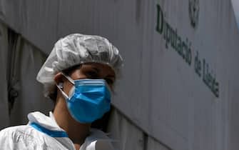 A healthcare workers wearing protective gear waits outside a field hospital set up for coronavirus cases outside the CAP Prat de la Riba primary care centre in Lerida (Lleida) on July 13, 2020. - A local court suspended a home confinement order imposed on more than 200,000 people in the Spanish region of Catalonia after an upsurge in virus cases. Catalonia officials ordered the home confinement on the city of Lerida and its surrounding areas a week after the zone had been placed under less strict lockdown. (Photo by Pau BARRENA / AFP) (Photo by PAU BARRENA/AFP via Getty Images)