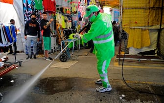 A municipal worker cleans and disinfects a sidewalk in Tepito neighborhood in Mexico City on July 12, 2020, amid the new coronavirus pandemic. (Photo by CLAUDIO CRUZ / AFP) (Photo by CLAUDIO CRUZ/AFP via Getty Images)