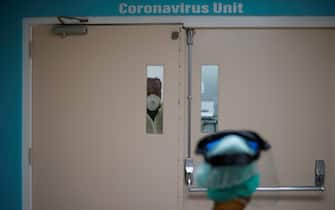 A healthcare worker looks out from a window in the door to the Covid-19 Unit at United Memorial Medical Center in Houston, Texas, July 2, 2020. - Despite its renowned medical center with the largest agglomeration of hospitals and research laboratories in the world, Houston is on the verge of being overwhelmed by cases of coronavirus exploding in Texas. (Photo by Mark Felix / AFP) / RESTRICTED TO EDITORIAL USE
TO GO WITH AFP STORY by Julia Benarrous: "Covid-19: Houston's hospital system underwater" (Photo by MARK FELIX/AFP via Getty Images)