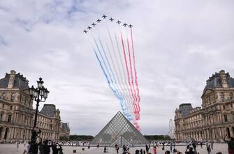 French elite acrobatic flying team "Patrouille de France" (PAF) performs a flying display of the French national flag over the Louvre pyramid designed by Chinese architect Ieoh Ming Pei, during annual Bastille Day military ceremony on the Place de la Concorde in Paris, on July 14, 2020. - France holds a reduced version of its traditional Bastille Day parade this year due to safety measures over the COVID-19 (novel coronavirus) pandemic, and with the country's national day celebrations including a homage to health workers and others fighting the outbreak. (Photo by Anne-Christine POUJOULAT / AFP) / RESTRICTED TO EDITORIAL USE - MANDATORY MENTION OF THE ARTIST UPON PUBLICATION - TO ILLUSTRATE THE EVENT AS SPECIFIED IN THE CAPTION (Photo by ANNE-CHRISTINE POUJOULAT/AFP via Getty Images)